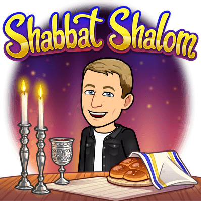 smiling next to a cup of wine lite candles and challah bread, shabbat shalom